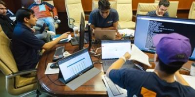 Group of cyber defense team members working at table together